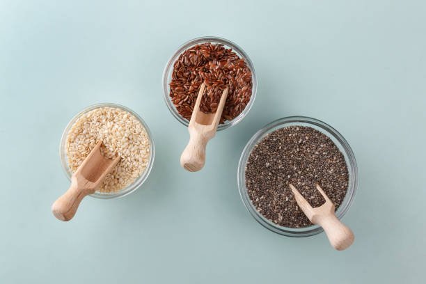 Comparativa de semillas de chía, lino y sésamo en un fondo natural de alimentos saludables